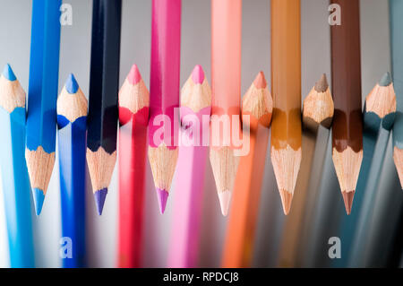 Close-up di giustapposti matita colorata suggerimenti su uno sfondo grigio neutro. Foto Stock