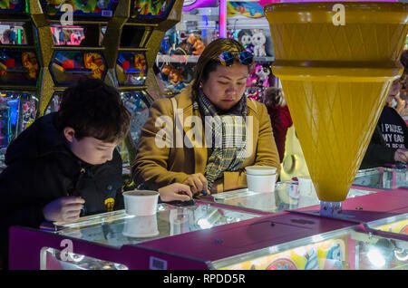 Una madre e figlio giocare due penny cade in una sala giochi a Bournemouth Dorset, Regno Unito Foto Stock