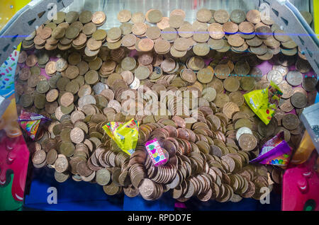 A due penny cade gioco dove due pence pezzo monete in precario equilibrio sul bordo di un ripiano inferiore in attesa di essere sbalzato fuori e ha vinto. Foto Stock