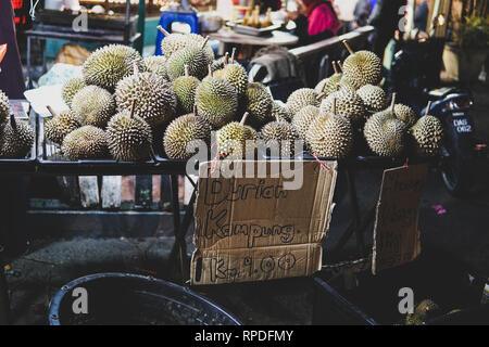 Durian - un frutto esotico con un molto sgradevole e forte odore è venduto sul mercato in Malaysia. Scritto nell'immagine 'Durian Kampung' significato villa Foto Stock