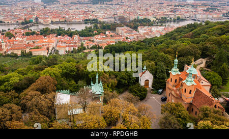 Drone vista del centro di Praga, dal di sopra della vicina collina di Petřín, su un nuvoloso giorno d'autunno. Chiesa di San Lorenzo in primo piano. Foto Stock