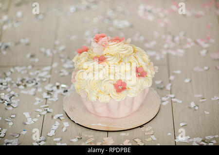 Primo compleanno di torta rosa con fiori per la piccola bambina e decorazioni per torta smash. Foto Stock