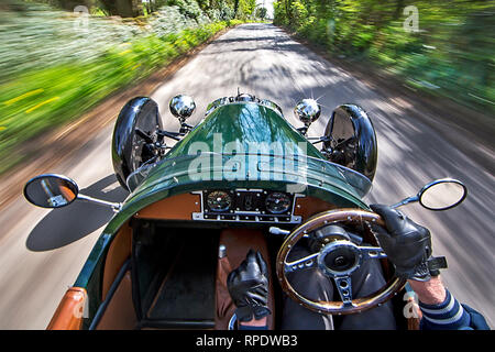 Morgan 3-auto ruota essendo azionato velocemente attraverso un paese di lingua inglese lane con scenario sfocata e un impresion di velocità. Rilasciare firmato. Foto Stock