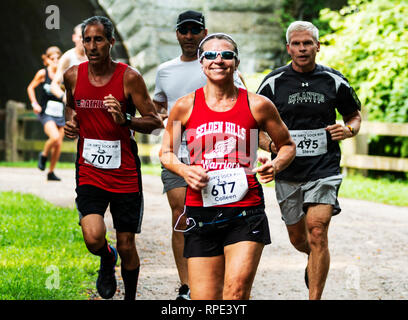 Babilonia, New York, Stati Uniti d'America - 12 August 2018: guide su un percorso sterrato nel bosco racing a 10K per la carità in estate godendo la loro giornata. Foto Stock