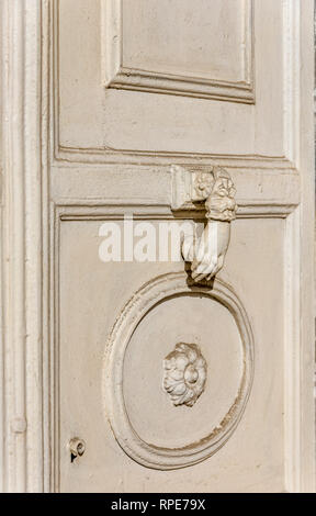 Vecchio scolpita porta bianca. vecchio palazzo bianco porta in legno e metallo bianco respingente Foto Stock