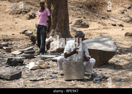 Un tradizionale stone mason il taglio di roccia sulla isola Elephanta, Mumbai. Abile lavoro di martello e di scalpello. Foto Stock