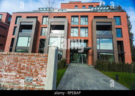 Moderno rosso mattone complesso di appartamenti con solida roccia della parete di recinzione. Home Immobili residenziali complesso immobiliare. Foto Stock