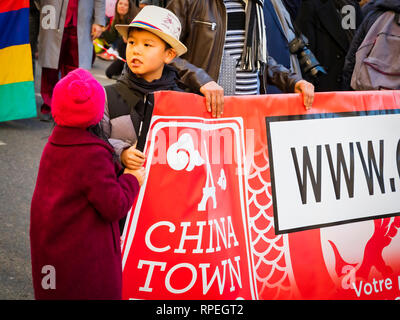 Parigi, Francia - 17 febbraio 2019. Ultimo giorno della celebrazione del Capodanno cinese festival in strada. due bambini azienda banner con chinatown scritto Foto Stock