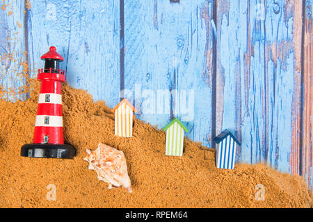 Il faro e la spiaggia di capanne in sabbia in spiaggia Foto Stock