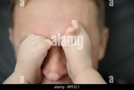 Del bambino in piedi sulla faccia di un adulto. Foto Stock