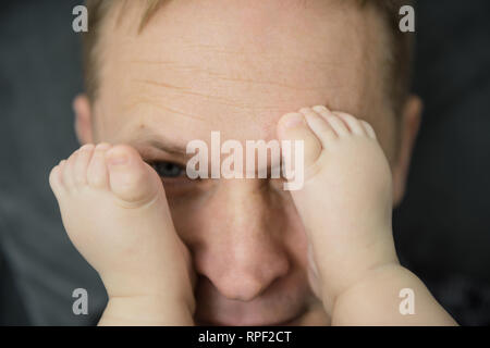 Del bambino in piedi sulla faccia di un adulto. Foto Stock