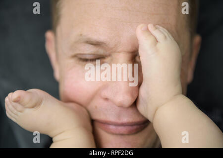 Del bambino in piedi sulla faccia di un adulto. Foto Stock