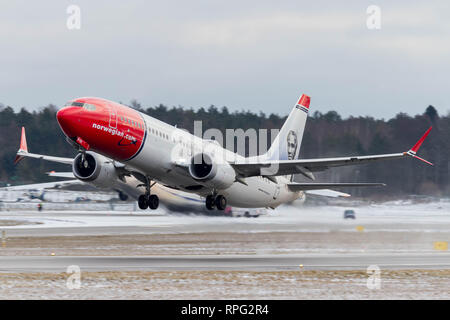 Norwegian Air Shuttle jet di decollare in un paesaggio innevato Foto Stock