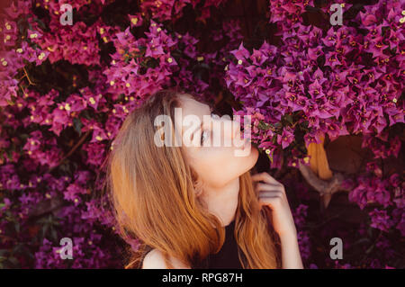 Ritratto di una ragazza che bacia bougainvillaea, primavera Foto Stock