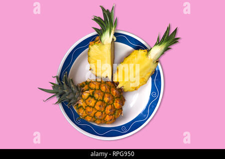 Una vista in pianta di un piano di giacitura di un ananas maturo con un sfondo rosa Foto Stock