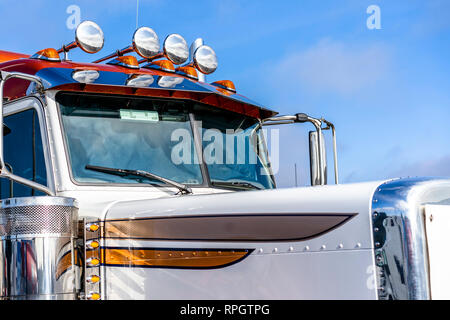 Orange long haul American logistica leader del trasporto merci trasporto big rig semi classico Carrello con corna audio sul tetto e chiuso il parabrezza del cockpit Foto Stock