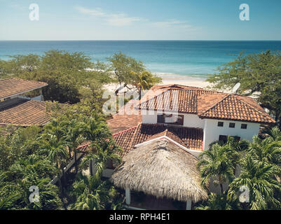 Lasciando in tema tropicale. villa di lusso sul mare spiaggia sfondo Foto Stock