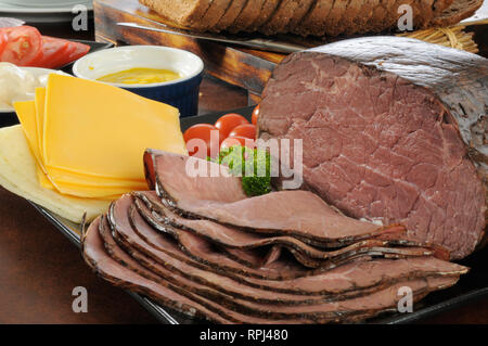 Sottili fette di arrosto di manzo con formaggio, condimenti e fette di pane di segale per panini Foto Stock