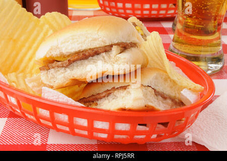 Un cestello di cursori o mini cheeseburger e patatine con la birra Foto Stock