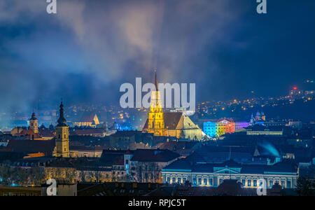La vecchia città di Cluj-Napoca con la chiesa francescana e la Chiesa di St. Michael visto dal Cetatuia parco di notte in Cluj-Napoca, Romania. Foto Stock