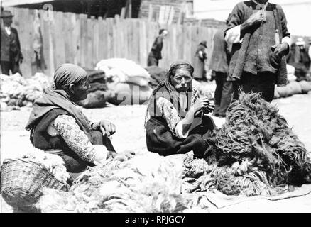 [Bulgaro contadino le donne in luogo di mercato, con pile di bianco e nero lana 1923 Foto Stock