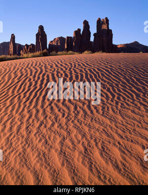 Stati Uniti d'America, Arizona, il parco tribale Navajo, Sunrise definisce la texture di dune di sabbia con torri di roccia chiamato Yei-Bi-Chei aumento nella distanza. Foto Stock