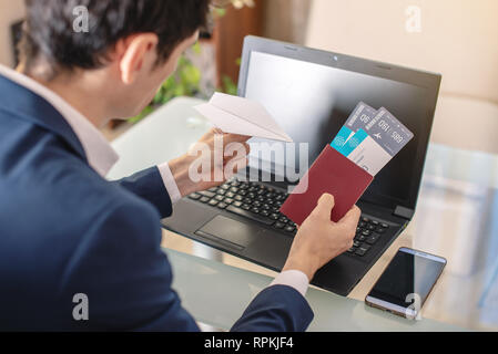 Imprenditore azienda biglietto aereo e passaporto acquisti su Internet utilizzando un computer portatile. Acquisto e prenotazione biglietti aerei online Foto Stock