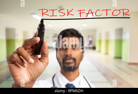 Medico indiano uomo sottolineando con il nero di close-up di fattori di rischio il testo in colore rosso invisibile sul display in vetro Foto Stock