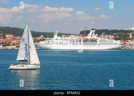 Lisbona, Portogallo - 03 Aprile 2010: barca a vela e la nave sul mare blu costa. Barca a vela e ocean liner in mare. Per viaggi di piacere. Viaggiare in acqua. Vacanze estive e wanderlust. Foto Stock