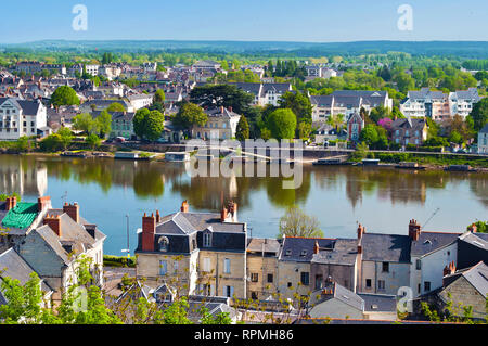 Vista mozzafiato sul sorprendente piccola città di Saumur, Francia. Molti di bianco e grigio case nei pressi di un fiume Loira, un sacco di alberi verdi e tetti. Calda primavera m Foto Stock