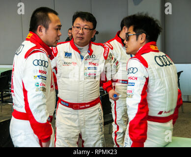 Hong Kong superstar Aaron Kwok in un huddle con altri piloti al driver riunione del 2013 Audi R8 LMS Cup sul circuito di Shanghai. Foto Stock