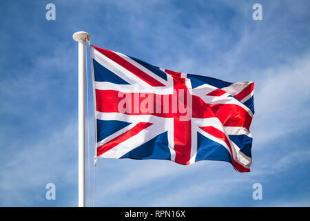 La bandiera nazionale del Regno Unito è la Union Jack, noto anche come l'Unione bandiera sventola sul vento oltre il cielo blu sullo sfondo. Foto Stock