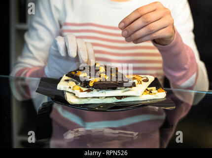 Il bianco e il nero delle tavolette di cioccolato con frutta secca ed essiccata Foto Stock