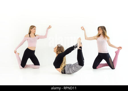 Un gruppo di tre ragazze giovani belle sono dancing. yoga e pilates sono praticate. Sfondo bianco Foto Stock