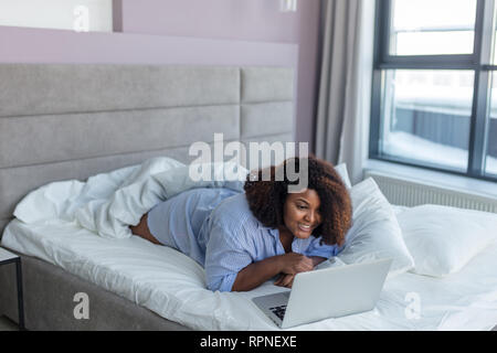 Giovane bella donna allegra navigando in rete la comunicazione on line, hobby Foto Stock
