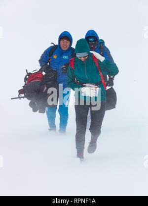 ALMATY KAZAKHSTAN - Febbraio 03 2019: persone non identificate a piedi attraverso una tempesta di neve durante il concorso AlpineRais in montagna durante il Foto Stock