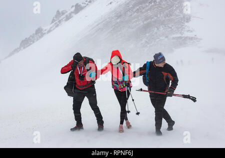 ALMATY KAZAKHSTAN - Febbraio 03 2019: persone non identificate a piedi attraverso una tempesta di neve durante il concorso AlpineRais in montagna durante il Foto Stock