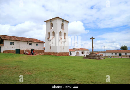 Imponente Croce e la torre campanaria della chiesa coloniale a Chinchero Hilltop, La Valle Sacra degli Inca, Cuzco, Perù Foto Stock