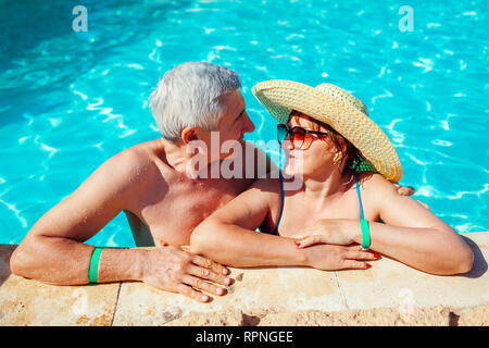 Coppia senior rilassante in piscina. Le persone felici godendo le vacanze estive. La formula all inclusive. Foto Stock