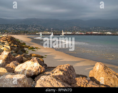 Spiaggia rocciosa e barche su acqua Foto Stock