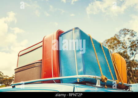 Pila di sacchi vintage sul tetto della vettura di viaggio fissata con fune Foto Stock