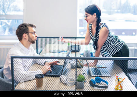 Giocoso longhaired ragazza a parlare con il suo collega Foto Stock