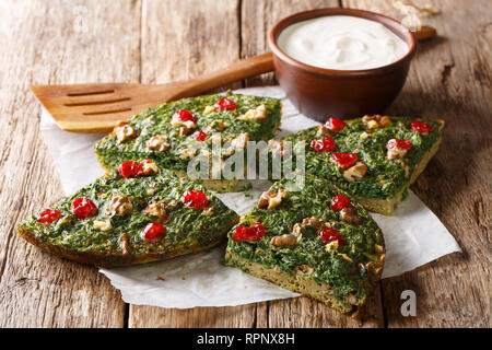 Deliziose omelette sani da erbe, uova e noci e frutti di bosco essiccati close-up su una tabella con yogurt. orizzontale Foto Stock