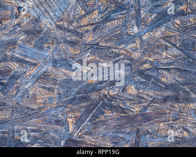 Pannelli OSB sono fatte di marrone da trucioli di legno levigato in uno sfondo di legno. Vista dall'alto di OSB di impiallacciatura di legno sfondo, stretto, superfici senza giunture. Foto Stock