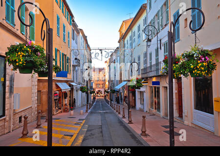 Strada colorato in Antibes marciapiede e negozi vista, Francia meridionale Foto Stock