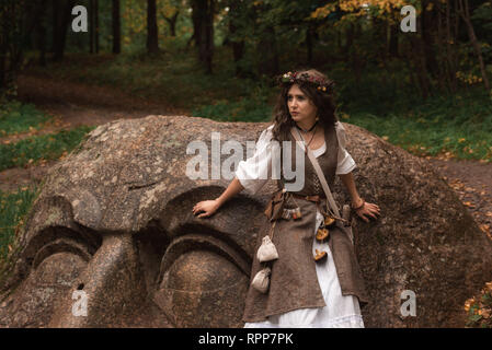 Un giovane strega in una foresta di autunno Foto Stock