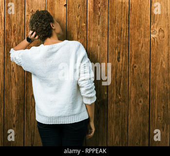 Bella giovane americano africano donna che indossa un maglione su sfondo isolato indietro pensando di dubbio con la mano sulla testa Foto Stock
