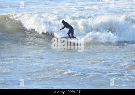 Aberystwyth Wales UK. Venerdì 22 Feb 2019 UK meteo: Surfers godendo incredibilmente caldo sole di febbraio in Aberystwyth sulla costa occidentale del Galles. Il tempo è previsto rimanere bene per i prossimi giorni con la possibilità di registrare le temperature di rottura in alcuni luoghi Photo credit: keith morris/Alamy Live News Foto Stock