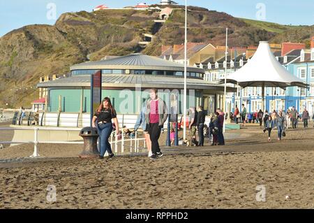 Aberystwyth Wales UK. Venerdì 22 Feb 2019 UK meteo: Peopke godendo incredibilmente caldo sole di febbraio in Aberystwyth sulla costa occidentale del Galles. Il tempo è previsto rimanere bene per i prossimi giorni con la possibilità di registrare le temperature di rottura in alcuni luoghi Photo credit: Keith Morris/Alamy Live News Foto Stock