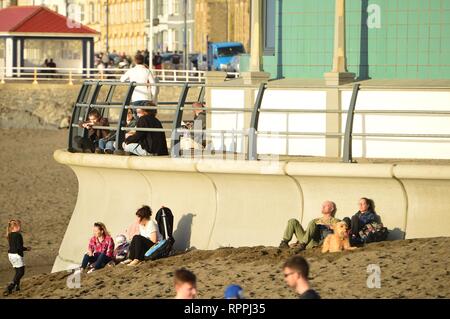 Aberystwyth Wales UK. Venerdì 22 Feb 2019 UK meteo: Peopke godendo incredibilmente caldo sole di febbraio in Aberystwyth sulla costa occidentale del Galles. Il tempo è previsto rimanere bene per i prossimi giorni con la possibilità di registrare le temperature di rottura in alcuni luoghi Photo credit: Keith Morris/Alamy Live News Foto Stock